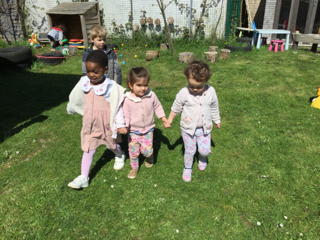 Children holding hands and walking together at Alton College Nursery